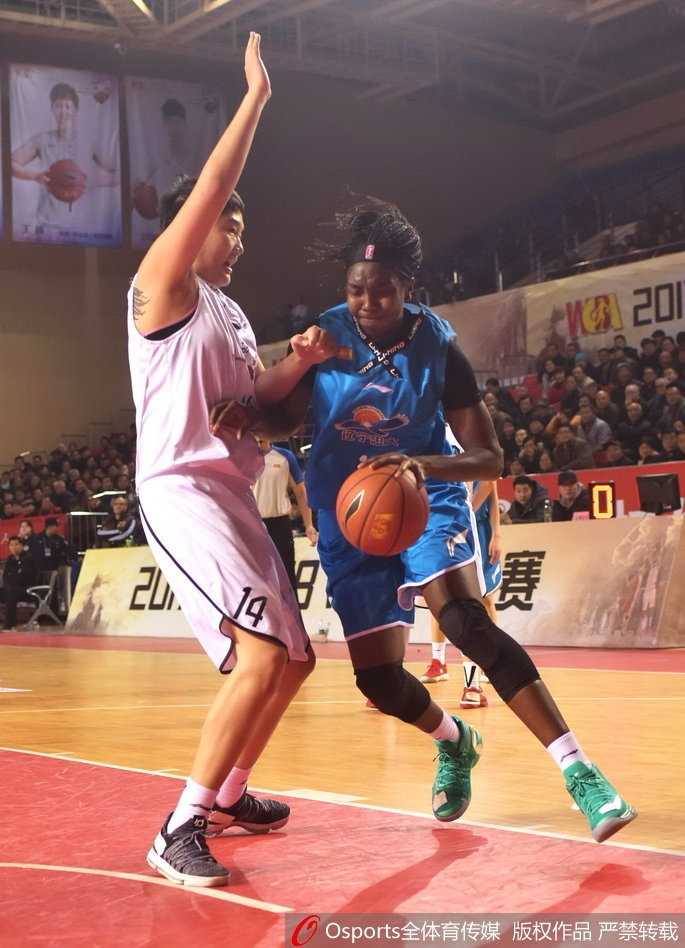 辽宁队球员在严密防守下强行出手，身体在空中失去平衡，依然奋力将球投向篮筐。