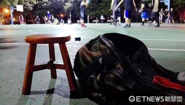 雨神的另一面:萧敬腾與他的摺疊凳籃球哲學 鏡頭拉近,蕭敬騰專注地看著場上的比賽,手裡拿著毛巾。他身後那張古樸的木頭板凳,在這個現代化的球場上顯得格外搶眼,仿佛在訴說著一位巨星回歸質樸、熱愛運動的初心。