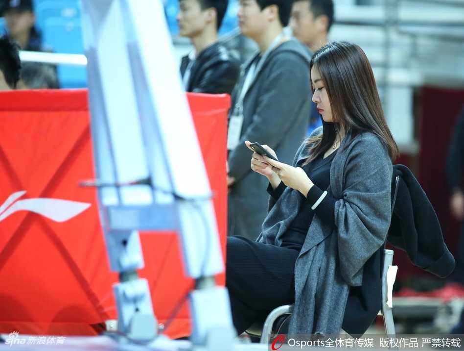 青岛主场那一抹亮色:高颜值女球迷的冬日热情 一位穿着时尚的短发女球迷侧身而立,在赛场背景的映衬下,轮廓分明,显得既酷又充满活力