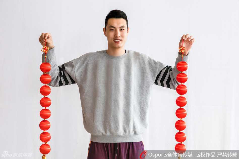 队友们围坐在一起，手里举着厚厚一摞红包，脸上绽放出孩子般的笑容，背景中隐约可见的冠军旗似乎也在为这喜庆时刻增添荣耀的光芒。