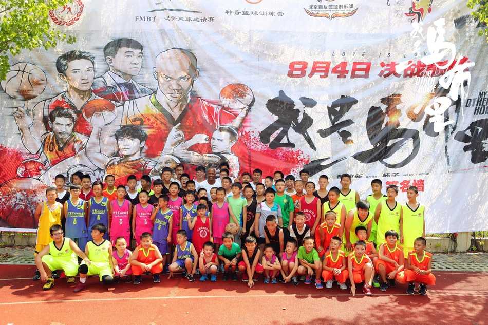 马布里认真地看着面前的小球员做运球动作，眼神中透露出专注与鼓励，仿佛在审视一颗未来之星的潜力。