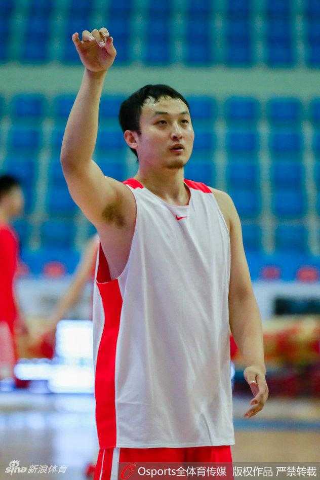 齐鲁之星闪耀塞上:丁彦雨航携“洗剪吹”新发型率山东男篮全运会预赛出征 山东全运男篮全队训练场景,丁彦雨航站在队伍中与队友交流战术,他的新发型在人群中格外显眼,整体氛围团结而专注。