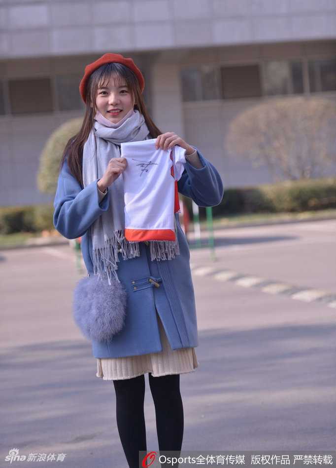 戴着可爱发饰的女球迷手托香腮，眼神灵动，似乎正在盘算着主队下一次进攻的走向，俏皮又专注。