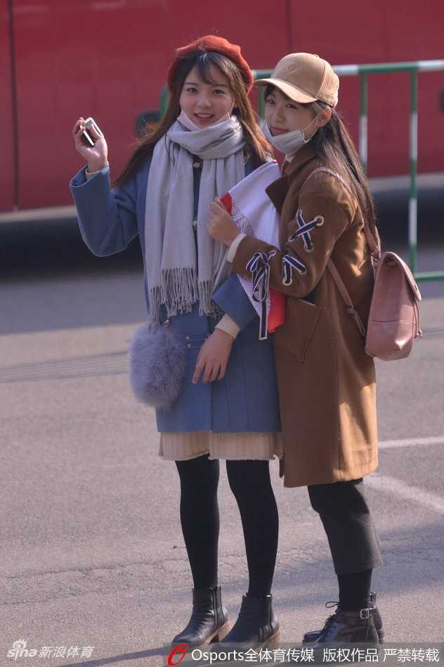 这位身穿简约休闲装的女球迷，眉眼如画，在赛场灯光的映衬下，宛如从画报中走出的电影明星。